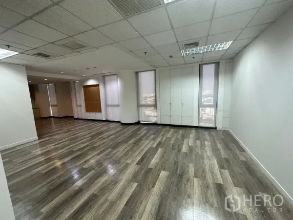 办公空间 出租 - 转角工作区，落地窗配卷帘，内置储物柜与木纹地板。