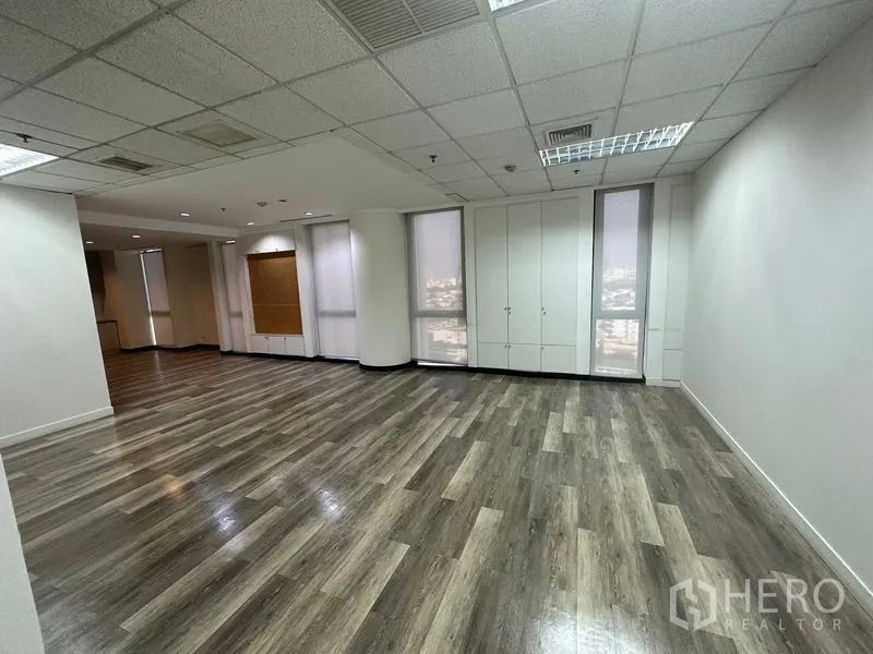 办公空间 出租 - 转角工作区，落地窗配卷帘，内置储物柜与木纹地板。