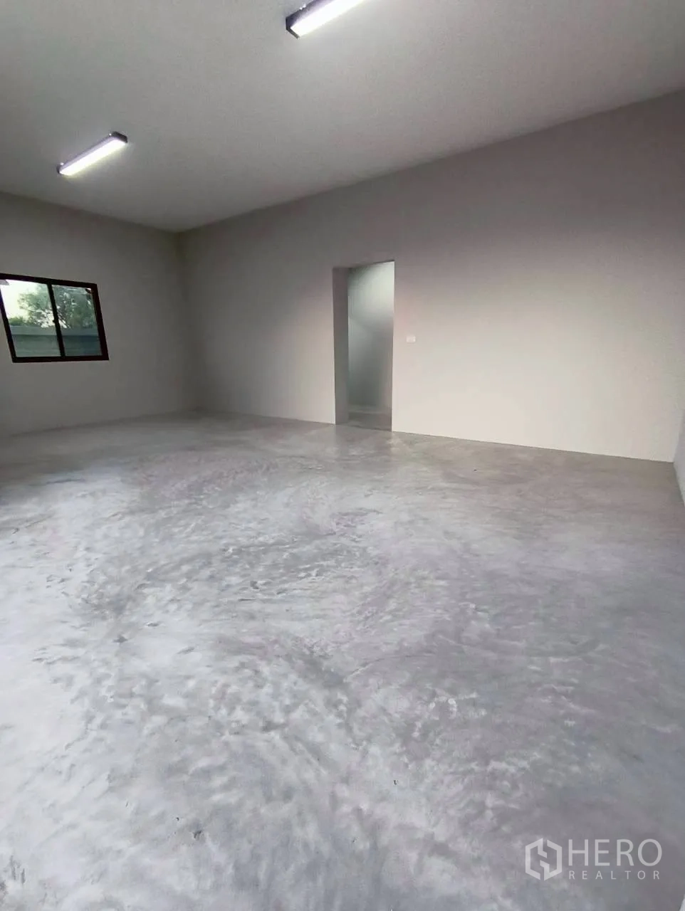 Warehouse for rent in Mueang Nonthaburi, Nonthaburi - Empty interior room with window, doorway, and overhead lighting.