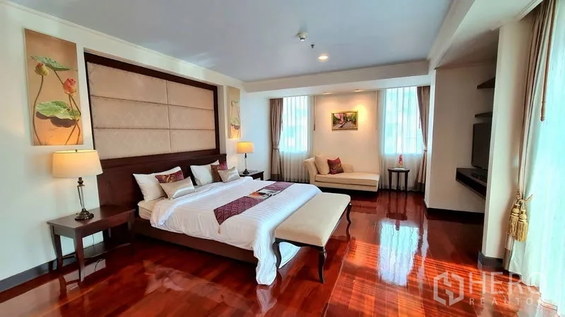 Apartment for rent in Watthana, Bangkok - Large bedroom with chaise lounge, bedside lamps and wide windows.