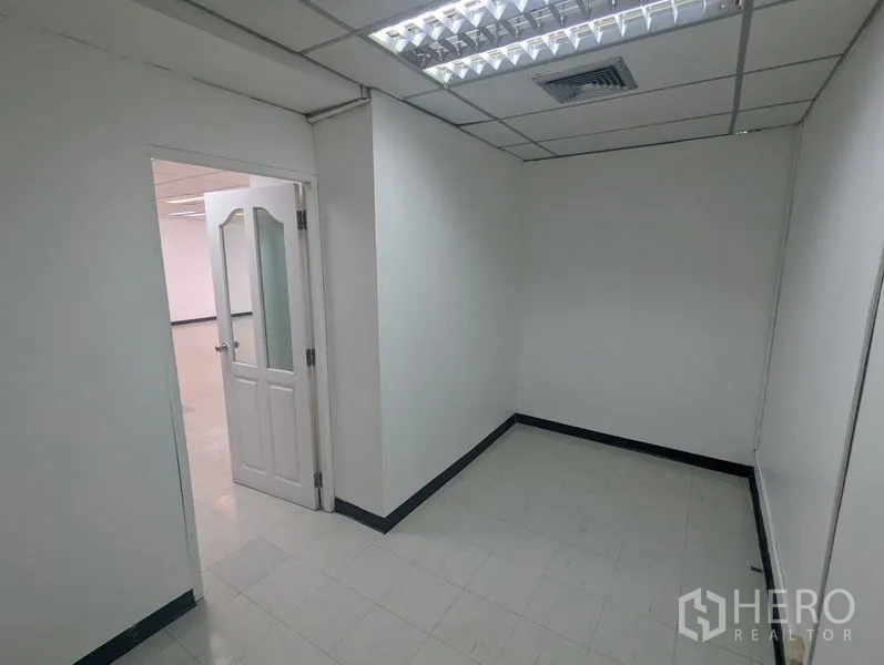 สำนักงาน ให้เช่าหรือขาย - ห้องทำงานส่วนตัวขนาดกะทัดรัด ผนังสีขาว พื้นกระเบื้อง และประตูกระจกใต้ไฟฟลูออเรสเซนต์