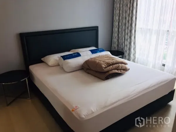 公寓 出租在Khlong Toei, Bangkok - 主卧配大床与床头柜，落地窗与窗帘带来充足自然光。