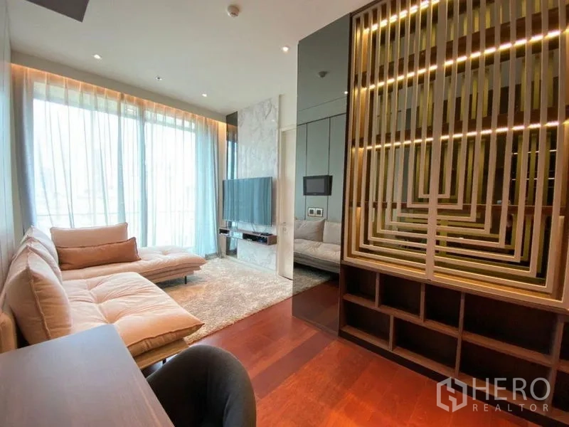 公寓 出租或出售在Watthana, Bangkok - 客厅配挂墙电视、木质格栅隔断和落地纱帘。