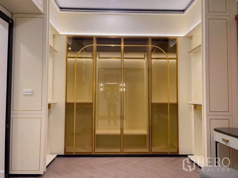 Detached House for rent in Saphan Sung, Bangkok - Luxury walk-in closet featuring gold-framed glass wardrobes and LED lighting.