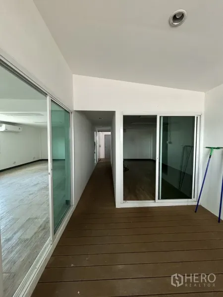 办公空间 出租在Watthana, Bangkok - 玻璃隔间走廊通向各办公室，木质地板。