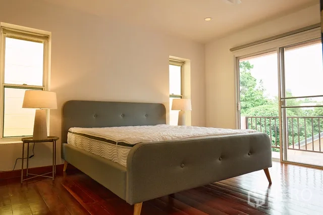 Detached House for rent in Watthana, Bangkok - Bedroom with gray upholstered bed and access to a balcony.