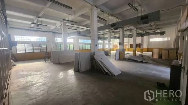 工厂 出租在Chom Thong, Bangkok - 宽敞生产车间，柱网、窗户与日光灯。