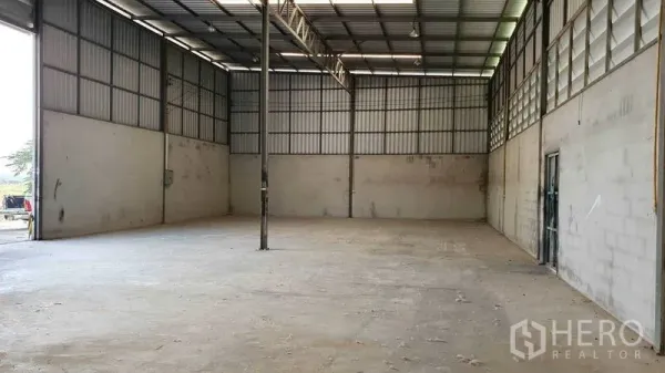 货栈 出租在Pathum Thani - 大跨距存储区，桁架屋顶、挑高墙体与平整混凝土地坪。