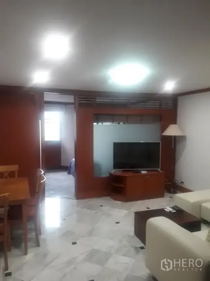 公寓 出租在Watthana, Bangkok - 客餐厅一体空间，铺大理石地面，木隔断、电视与沙发