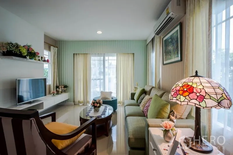 Detached House for sale in Bang Kapi, Bangkok - Cozy living room with sofa set, TV console and floor-to-ceiling windows.