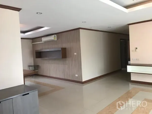 房间 出租在Watthana, Bangkok - 宽敞客厅，光洁瓷砖地面，墙面置物架及空调。