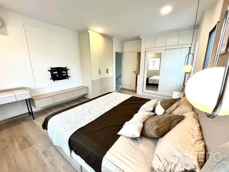Detached House for rent - Master bedroom angle showing fitted wardrobes, dressing desk and wood flooring.