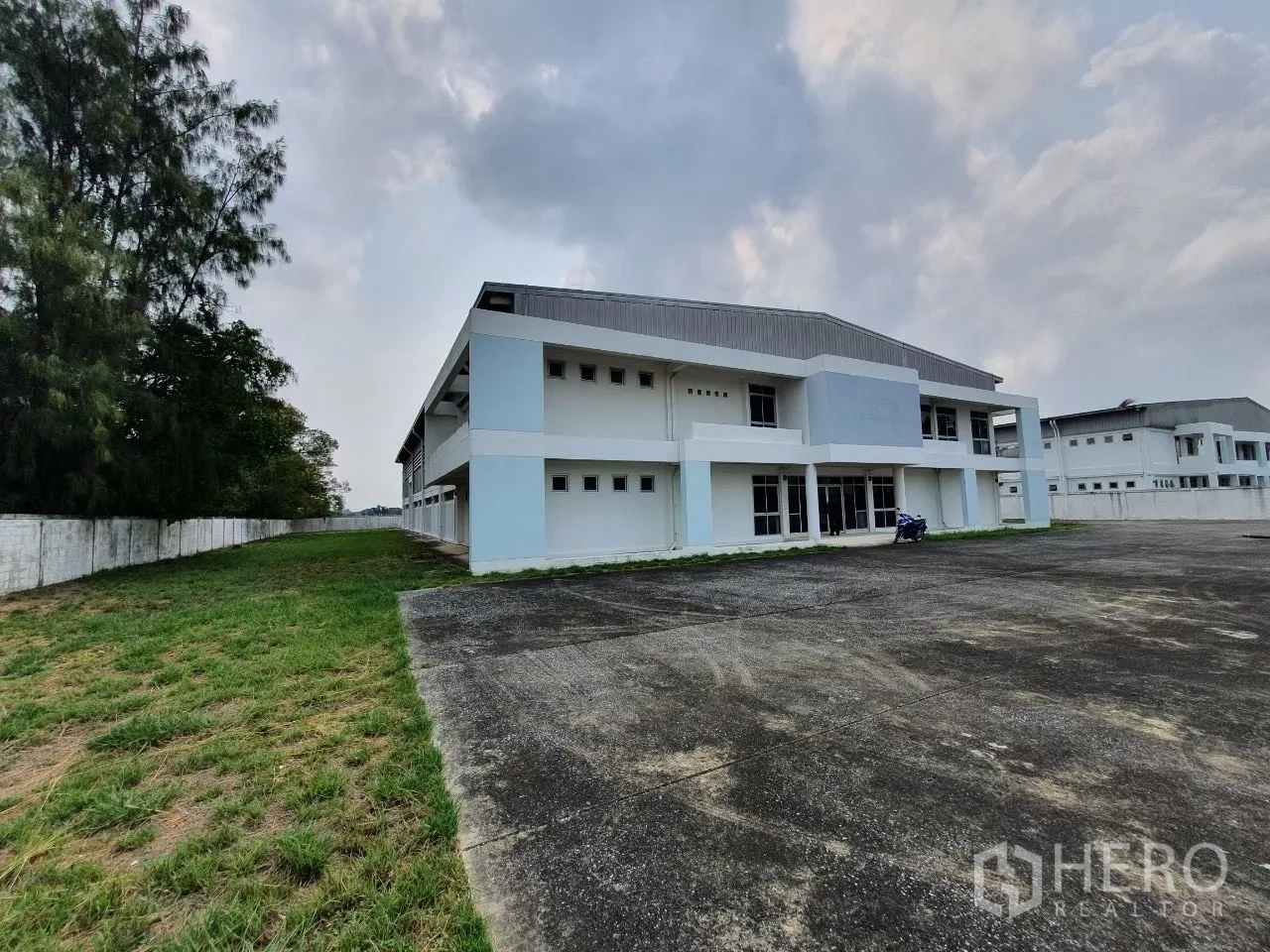 โรงงาน for rent in Bang Pa-in, Phra Nakhon Si Ayutthaya - อาคารโรงงานสองชั้นพร้อมลานคอนกรีตกว้างและรั้วรอบ.