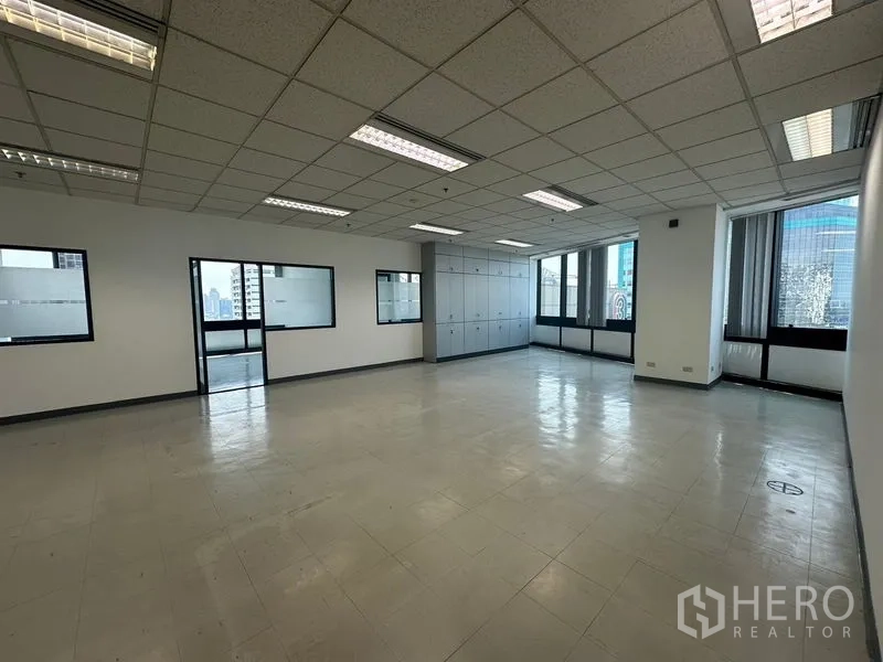 办公空间 出租在Khlong Toei, Bangkok - 宽敞开放式办公室，网格吊顶灯、窗户与内置储物柜。
