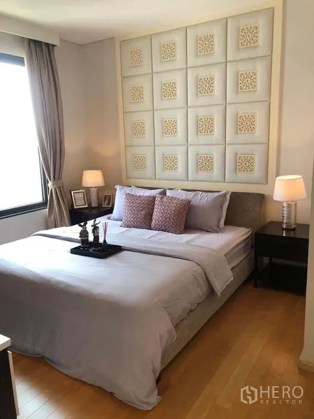 公寓 出租在Ratchathewi, Bangkok - 温馨卧室，软包背景墙与床头灯。