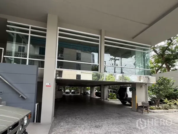 零售空间 出租在Watthana, Bangkok - 位于曼谷Ekkamai的现代化大楼入口，玻璃幕墙与下方停车区。