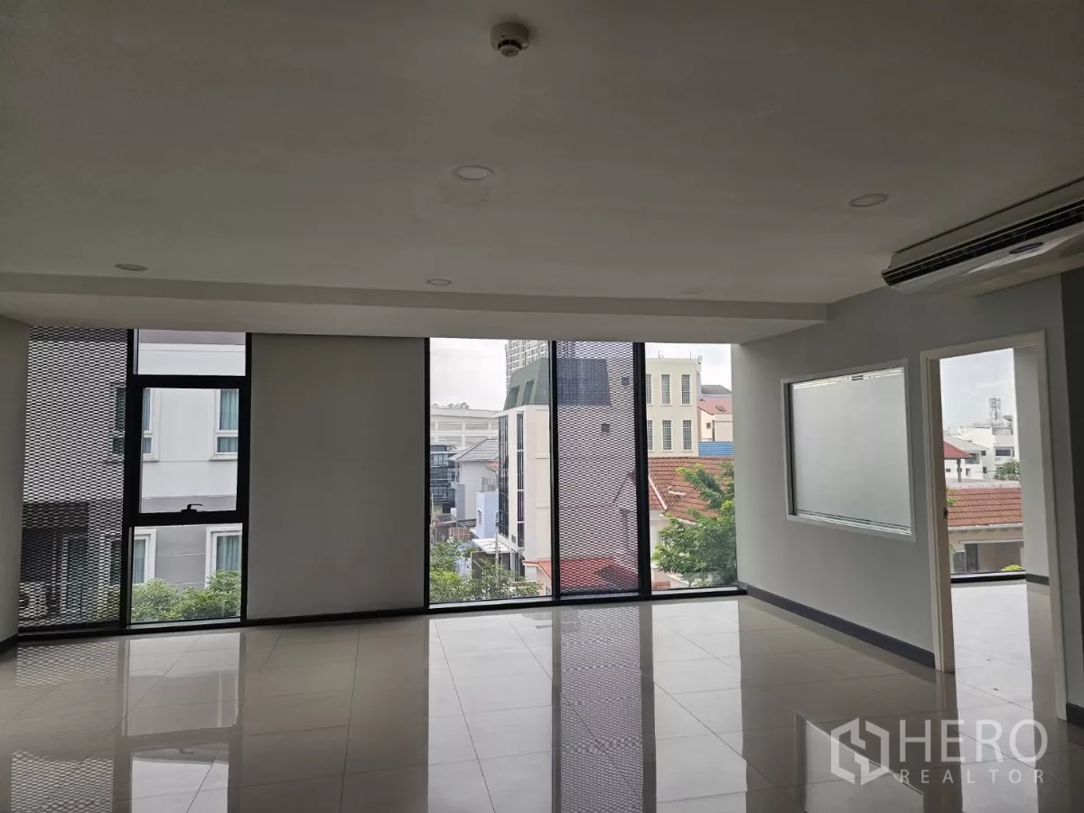 办公空间 出租在Sathon, Bangkok - 采光充足的办公区，多扇窗、局部玻璃隔断与社区景观。