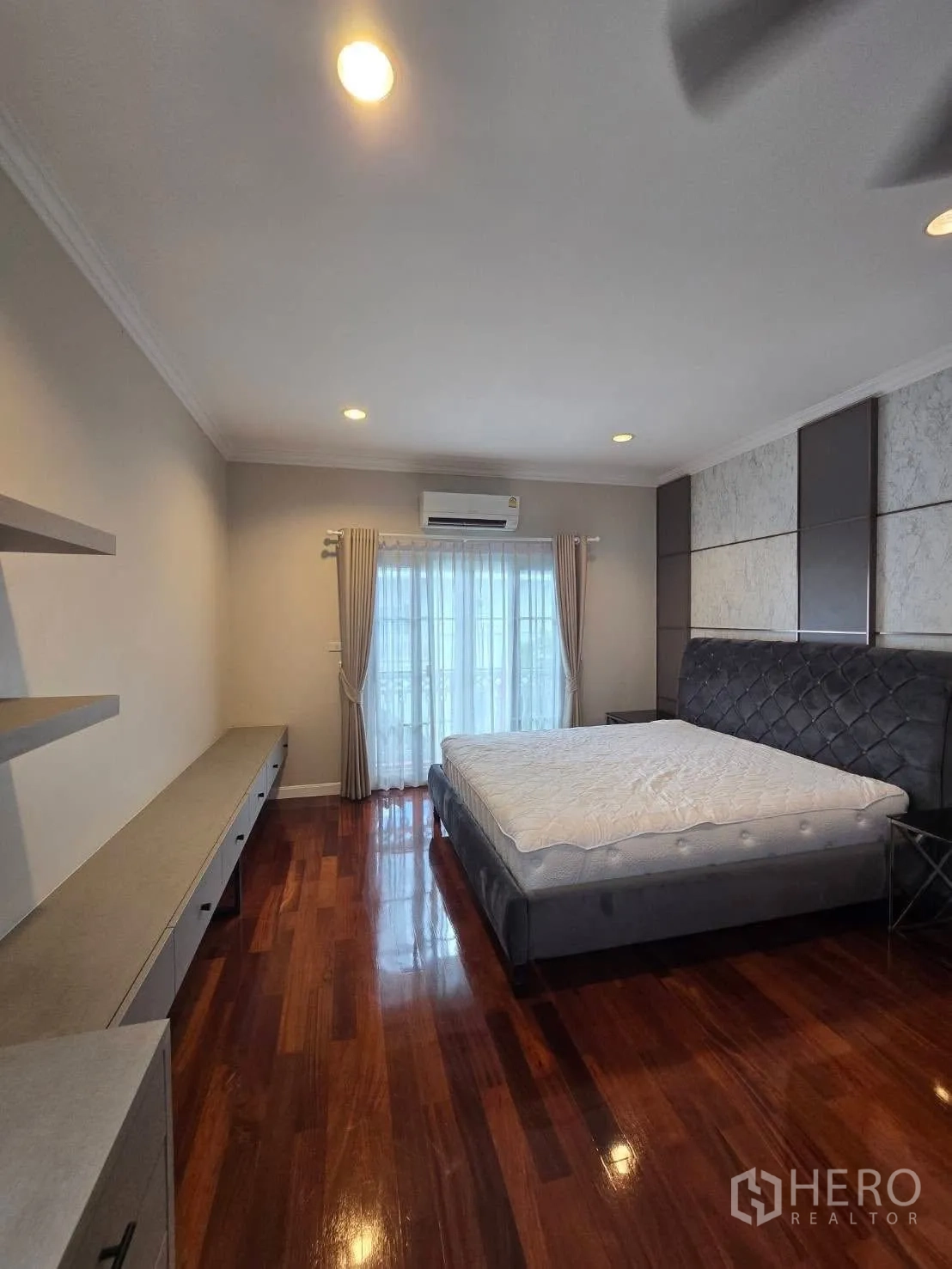 บ้านเดี่ยว for rent in Bang Na, Bangkok - ห้องนอนพร้อมเตียงขนาดใหญ่ พื้นไม้ และตู้วางของผนัง