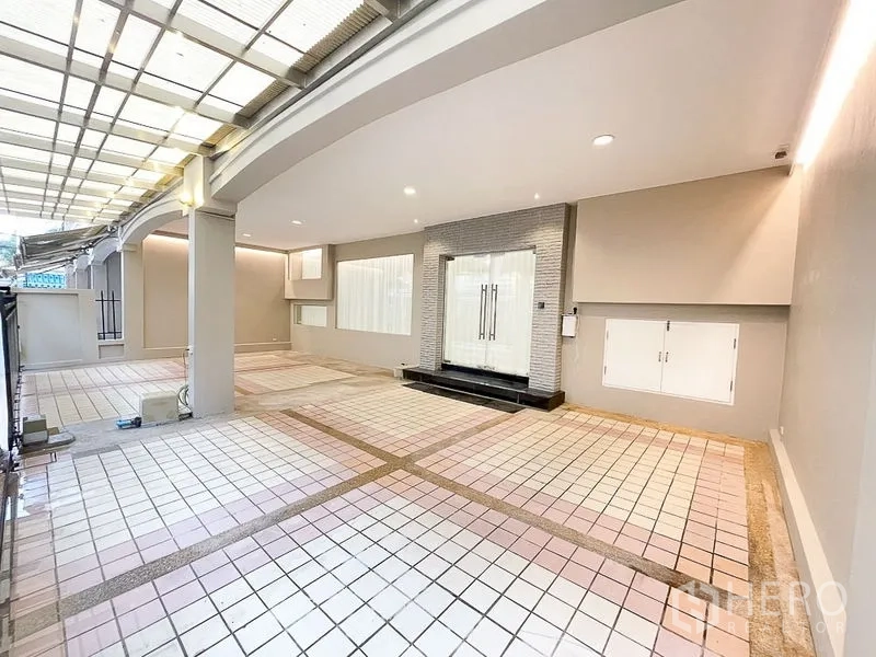 Townhouse for rent in Yan Nawa, Bangkok - Covered carport with tiled flooring, recessed lighting and glass double-door entry.