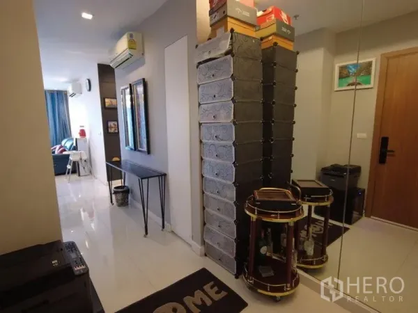 公寓 出租在Watthana, Bangkok - 入口走廊，带高储物柜、整面镜子与亮面地砖通往客厅
