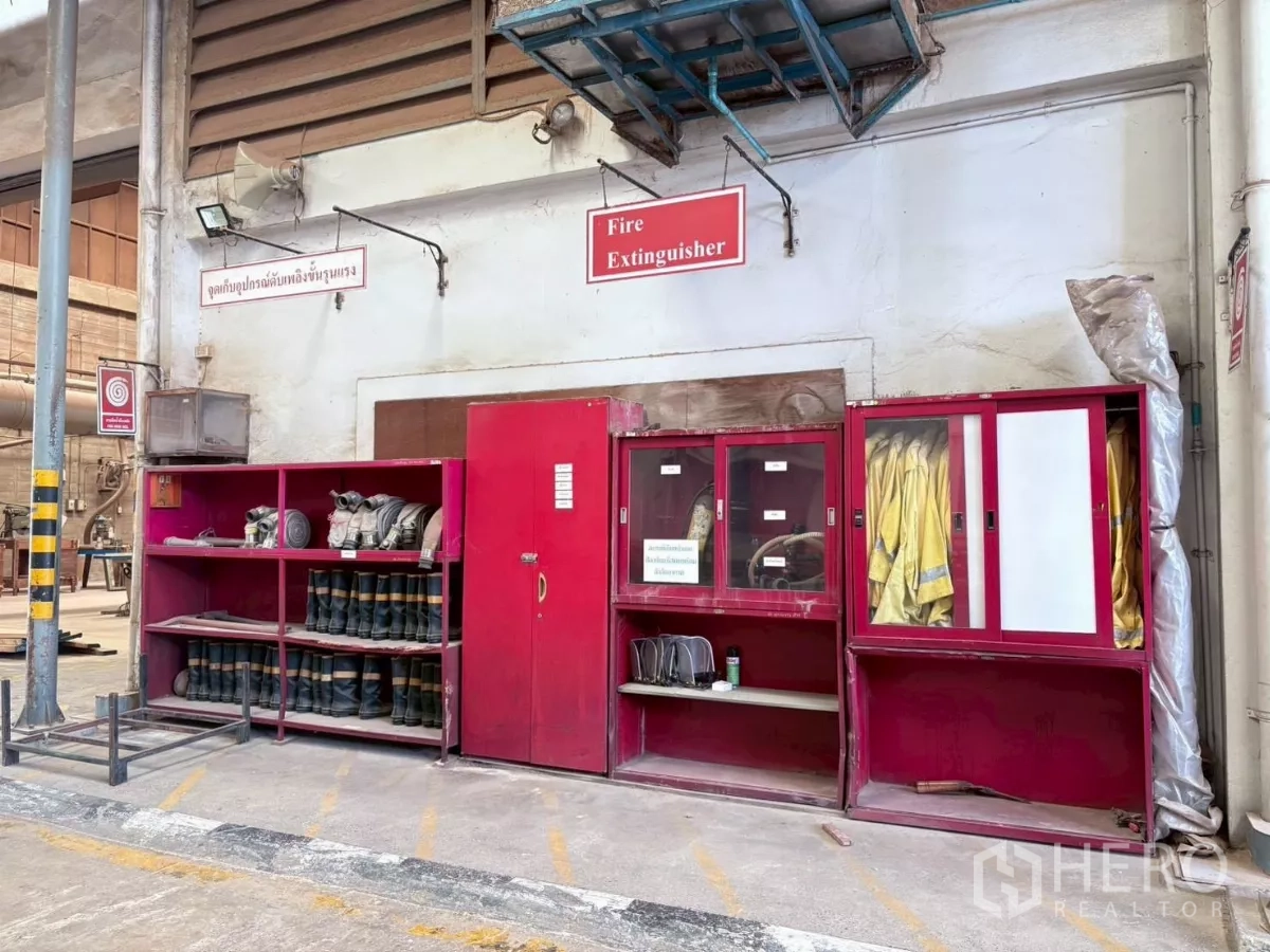 工厂 出租或出售在Bang Khun Thian, Bangkok - 墙面消防装备柜，摆放靴子、外套与设备。
