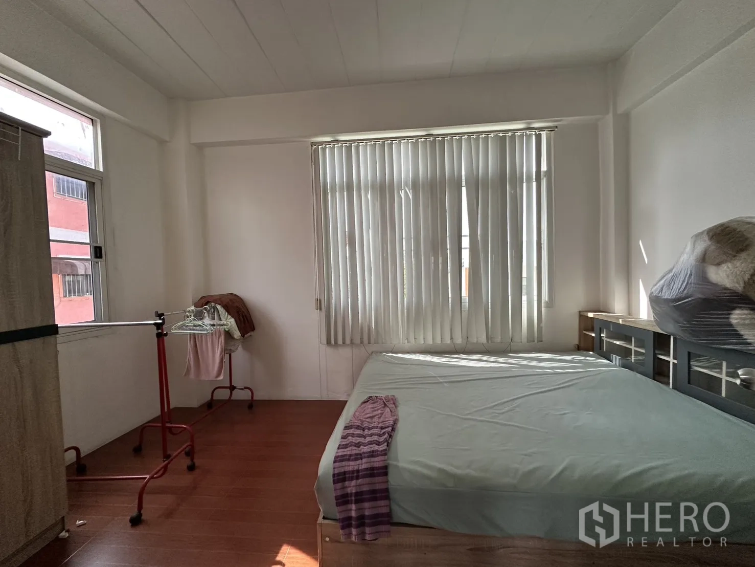 Shophouse for rent in Phra Khanong, Bangkok - Bedroom with bed, large windows, and vertical blinds.