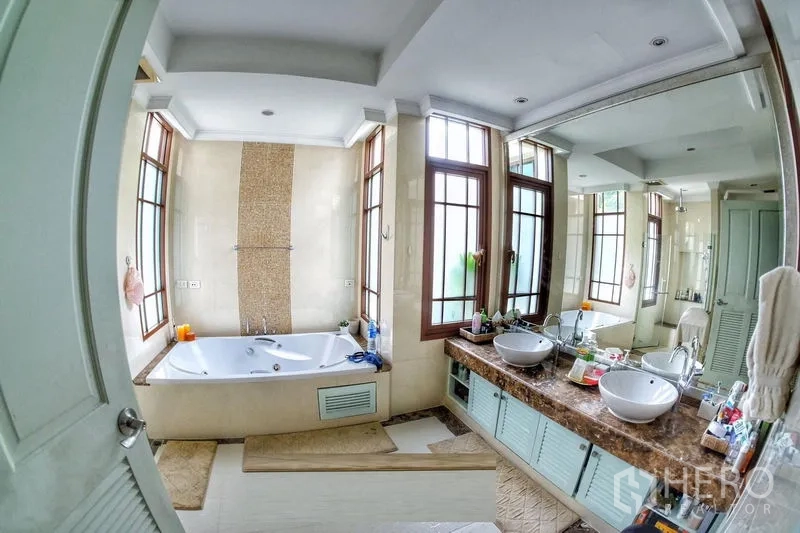 Detached House for rent in Watthana, Bangkok - Luxury bathroom with soaking tub, double vanity and tall windows for natural light.
