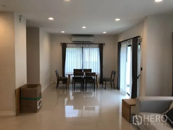 Detached House for rent in Bang Kapi, Bangkok - Dining area with wooden table and chairs, sheer curtains and glossy tile floors.