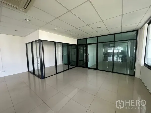 Office Space for rent - Bright Watthana office interior with glass-partitioned meeting rooms, tiled floors and drop ceiling.