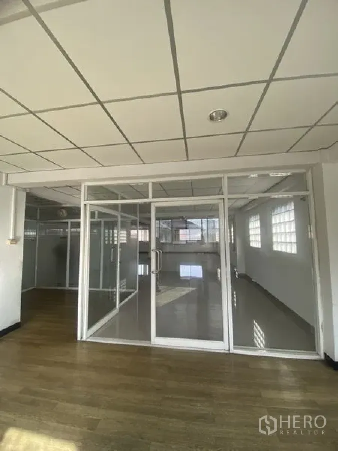 办公空间 出租在Khlong Toei, Bangkok - 玻璃隔断的会议室，双扇玻璃门，旁为木纹地面办公区。