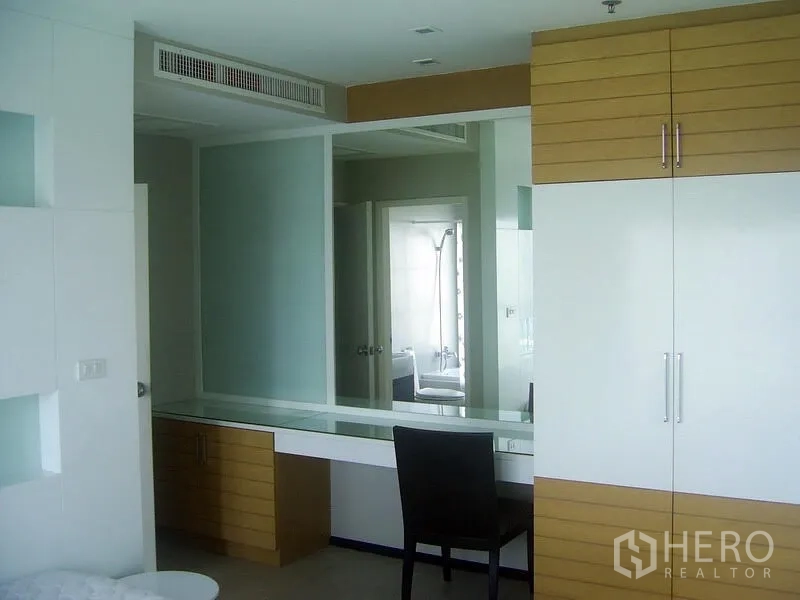 Condominium for rent in Khlong Toei, Bangkok - Second bedroom with long dressing desk, built-in wardrobe and door to bathroom.