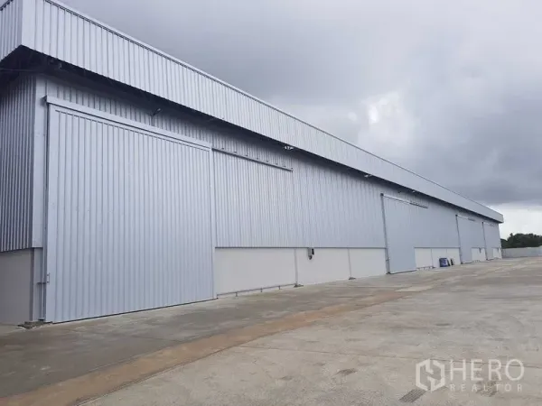 货栈 出租在Lat Krabang, Bangkok - 金属外墙仓库外立面，滑动大门与宽阔混凝土场地。