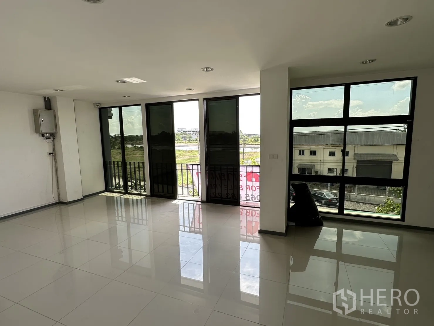 Factory for rent or sale in Pathum Thani - Upper office room with full-height windows overlooking green fields.