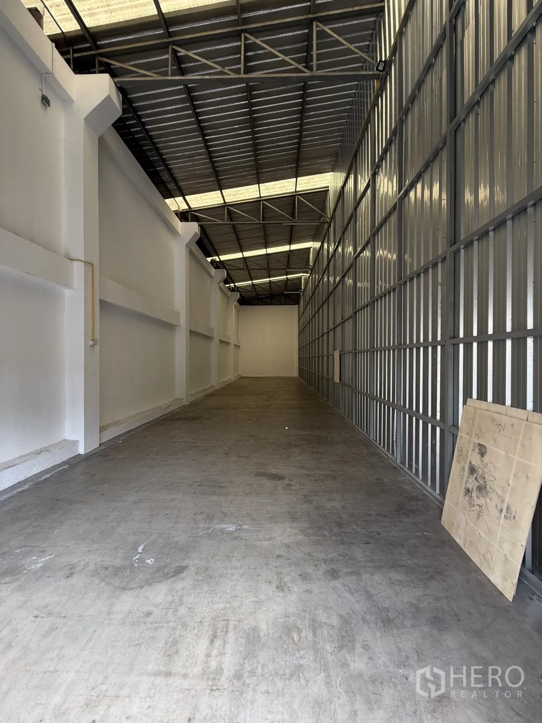 Warehouse for rent in Suan Luang, Bangkok - Deep aisle of the warehouse showing open span, concrete floor, metal cladding, and roof structure.