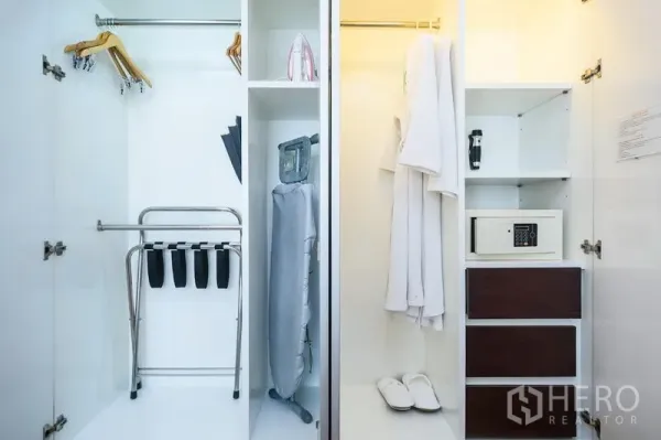 Condominium for rent in Khlong Toei, Bangkok - Built-in wardrobe with hangers, ironing board, safe and organized shelving.