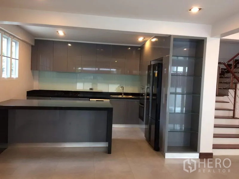 Detached House for rent or sale in Khan Na Yao, Bangkok - Contemporary built-in kitchen with island, glossy cabinets and appliances