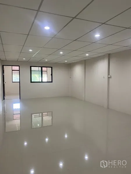 Townhouse for rent in Suan Luang, Bangkok - Wide bedroom space with glossy white tiles, grid ceiling and twin windows.