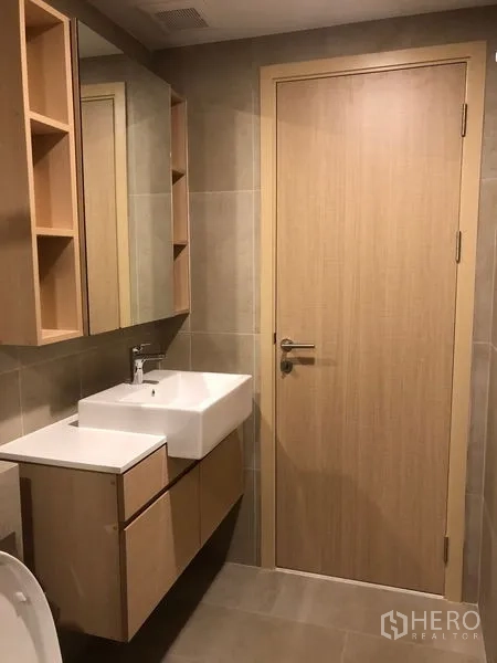 公寓 出租或出售在Yan Nawa, Bangkok - 浴室盥洗区，方形台盆、镜柜与木质收纳。