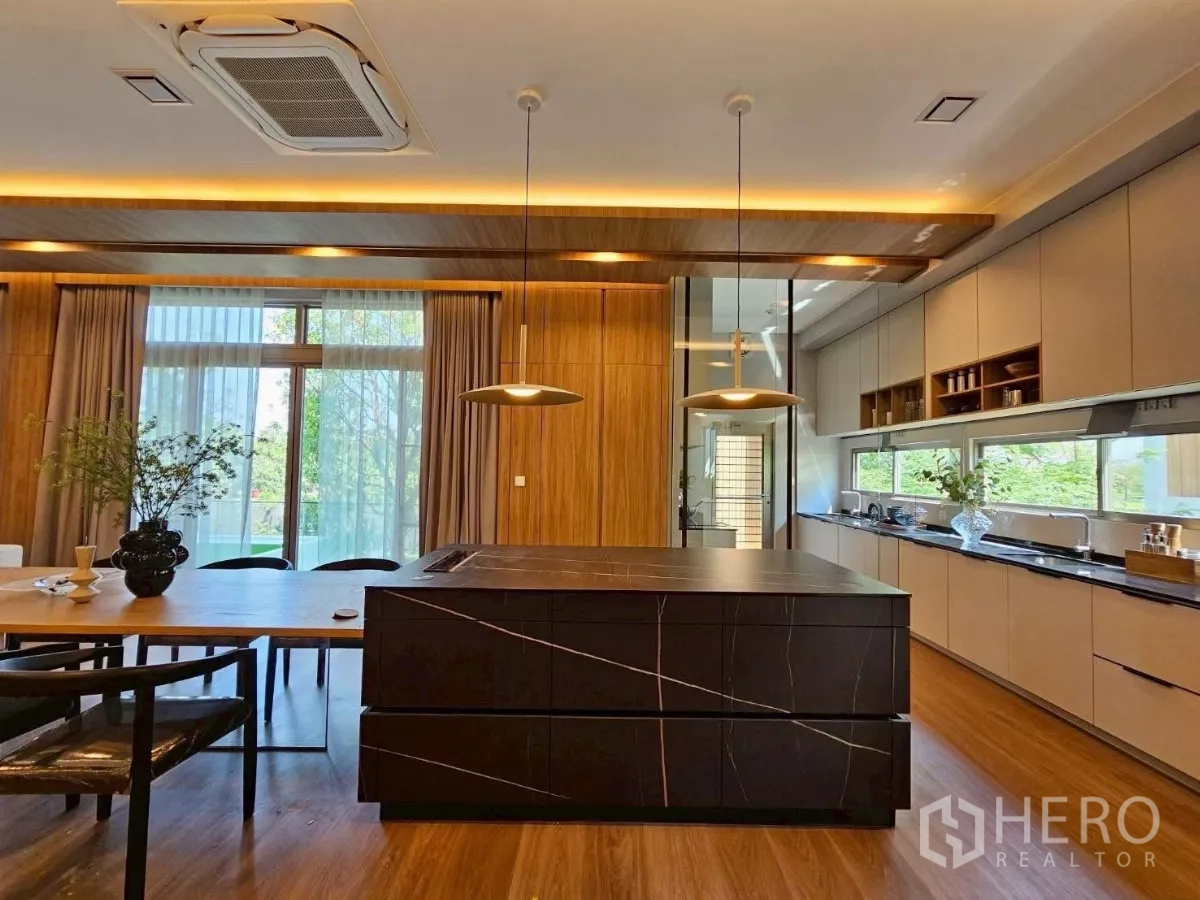Detached House for rent in Saphan Sung, Bangkok - Kitchen island with stone countertop facing a long linear pantry.
