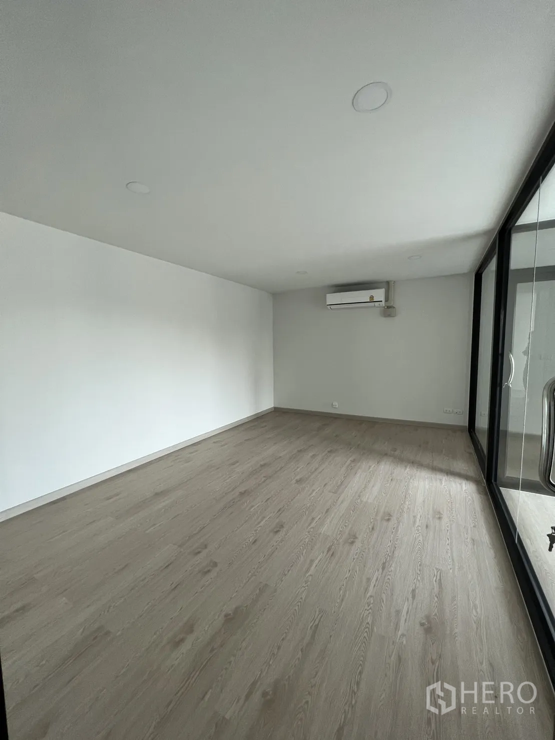 Home Office for rent in Bang Phli, Samut Prakan - Private glass‑enclosed room with wood floors and wall‑mounted air‑conditioner.