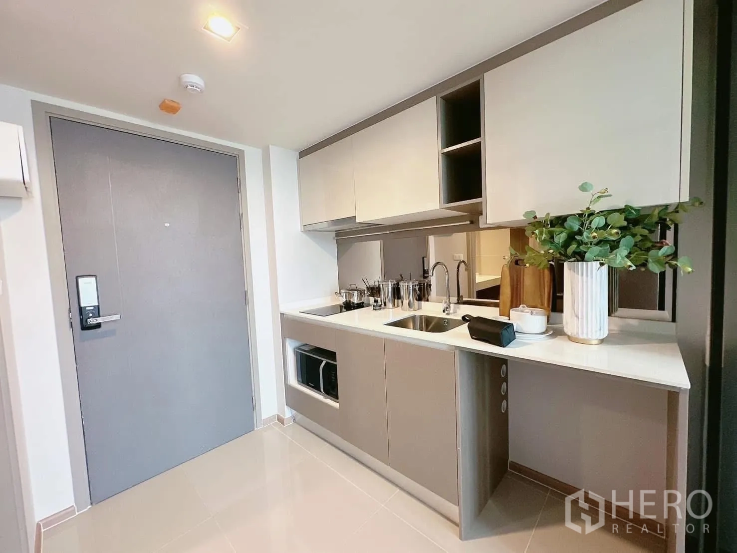 คอนโด ให้เช่าในHuai Khwang, Bangkok - ครัวยุโรปขนาดกะทัดรัด เคาน์เตอร์สีขาว ตู้บิลท์อิน อ่างล้างจาน และเตาไฟฟ้า ใกล้ประตูทางเข้า