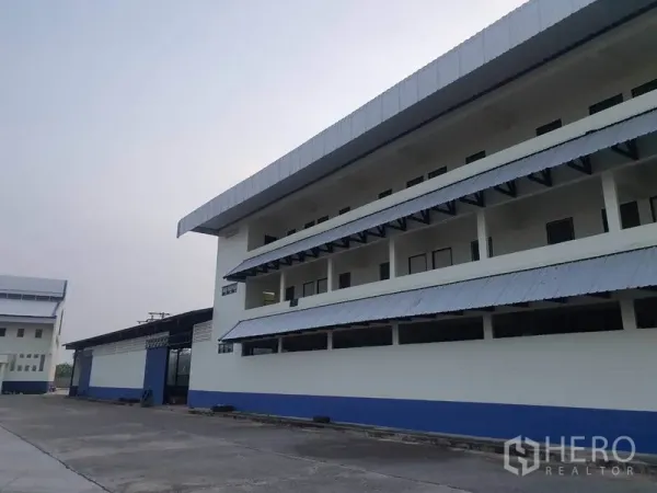 Factory for rent in Bang Bua Thong, Nonthaburi - Close-up of the office wing showing long balconies and metal awnings.