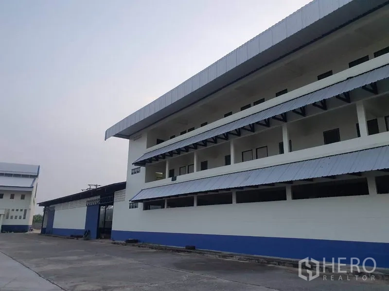 Factory for rent in Bang Bua Thong, Nonthaburi - Close-up of the office wing showing long balconies and metal awnings.