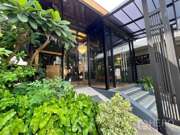 Retail Space for rent in Bangkok - Lush landscaped entry with steps and a glass façade beneath a crystal chandelier.