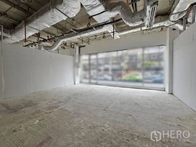 Retail Space for rent - Open-plan shop unit with white partition walls, full-width windows and exposed ceiling services.
