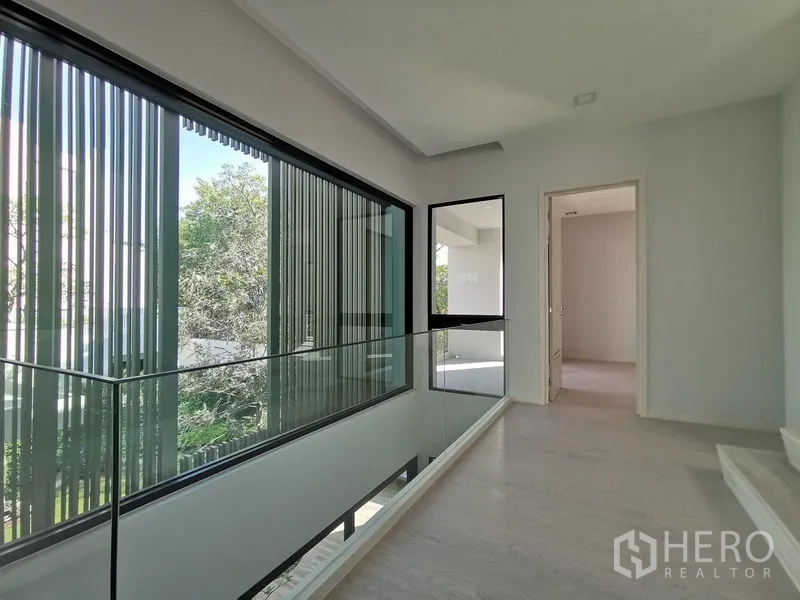 บ้าน ขายในSaphan Sung, Bangkok - โถงชั้นลอยสว่างพร้อมหน้าต่างเต็มผนังและราวกระจก.