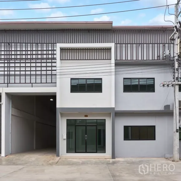 โรงงาน ให้เช่าในMueang Samut Sakhon, Samut Sakhon - ด้านหน้าโรงงานสองชั้นสมัยใหม่ พร้อมทางเข้าออฟฟิศกระจกและลานคอนกรีต.