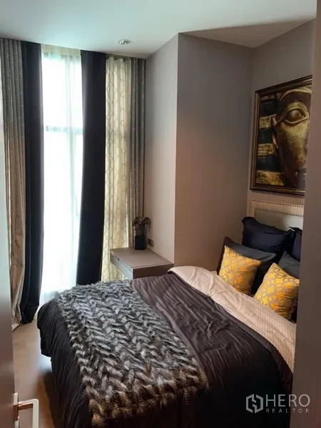 Condominium for rent in Bang Rak, Bangkok - Cozy second bedroom with dark bedding, gold cushions, artwork, and tall curtains in a Bang Rak condominium.