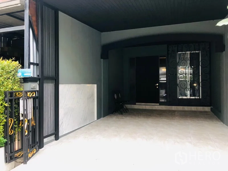 Townhouse for rent in Bang Kapi, Bangkok - Covered carport and secure front entrance with wrought-iron gate.