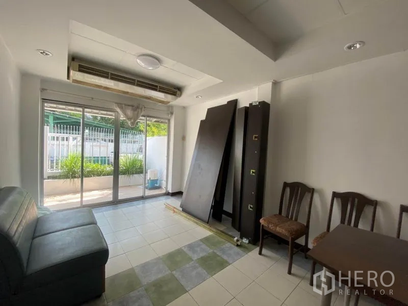 联排别墅 出租在Watthana, Bangkok - 一层起居区，落地推拉门通向前院，吊顶式空调。